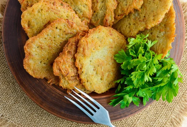 Panqueques vegetarianos de pueblo hechos de papas en un tazón de barro . — Foto de Stock