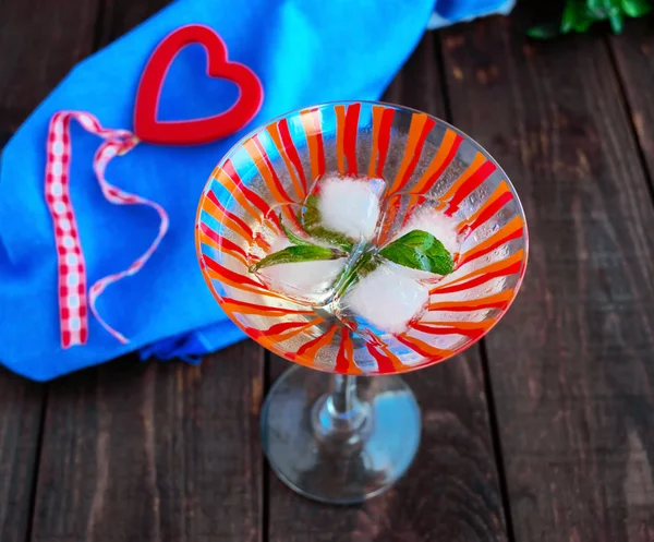 Glas mit Cocktail und Eiswürfeln und Minze auf der hellen Serviette — Stockfoto
