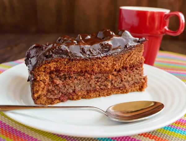 Gâteau au chocolat et cerise. Une pièce sur une assiette blanche — Photo