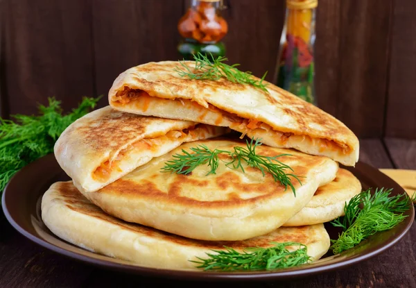 Rustic yeast cakes with cabbage in a clay bowl — Stock Photo, Image