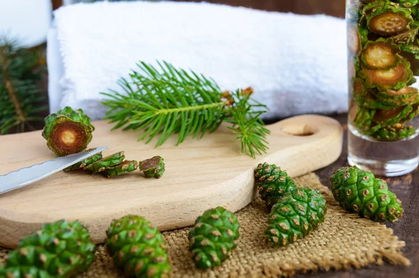 Young green fir cones on the wooden background. Chopping knife cones for making medicinal infusion. — Stock Photo, Image