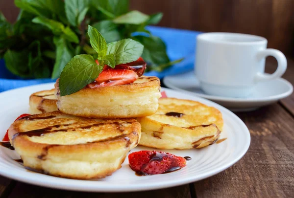 新鮮なイチゴと白いプレートとコーヒーのカップのチョコレートの素朴なパンケーキ. — ストック写真