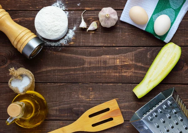 The ingredients and tools for cooking pancakes from zucchini