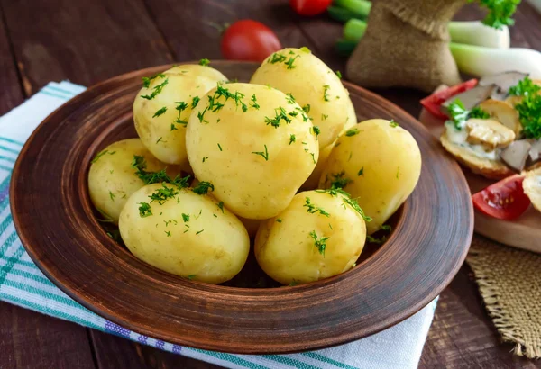 Ung kokt potatis med smör och dill i en lera skål — Stockfoto