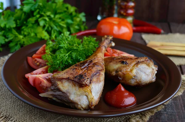 Roasted goose leg, sauce, herbs and tomatoes in a clay bowl — Stock Photo, Image