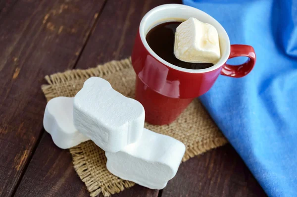 Ένα φλιτζάνι μαύρο καφέ και γλυκό marshmallow σε σκούρο φόντο ξύλινη — Φωτογραφία Αρχείου