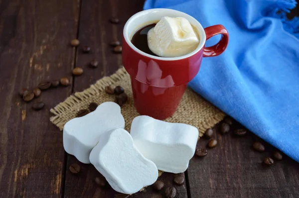 Ένα φλιτζάνι μαύρο καφέ και γλυκό marshmallow σε σκούρο φόντο ξύλινη — Φωτογραφία Αρχείου