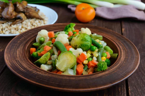 Dans un bol d'argile, faire cuire à la vapeur les légumes d'été (brocoli, maïs sucré, asperges, choux de Bruxelles, carottes). Légère garniture végétalienne alimentation — Photo