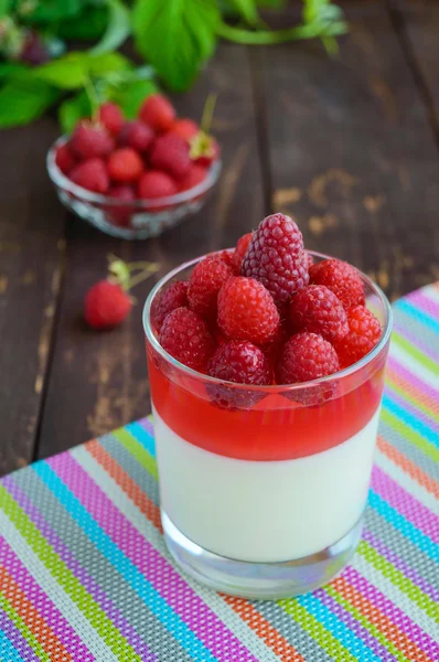 Zomer dessert met room en frambozen gelei, versier met verse bessen in een transparant glas — Stockfoto