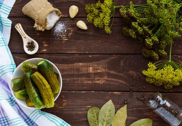 Gezouten komkommer. Specerijen en kruiden voor het maken van de augurken. Het bovenaanzicht van de houten achtergrond. — Stockfoto