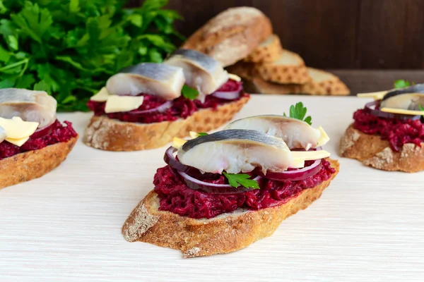 Sanduíche dietético sem carne: beterrabas cozidas, cebola roxa, arenque salgado e flocos de queijo defumado em uma baguete crocante . — Fotografia de Stock