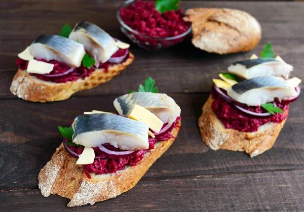 Sanduíche dietético sem carne: beterrabas cozidas, cebola roxa, arenque salgado e flocos de queijo defumado em uma baguete crocante . — Fotografia de Stock