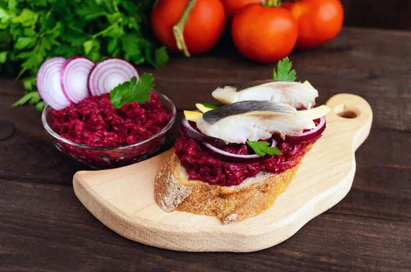 Sanduíche dietético sem carne: beterrabas cozidas, cebola roxa, arenque salgado e flocos de queijo defumado em uma baguete crocante . — Fotografia de Stock