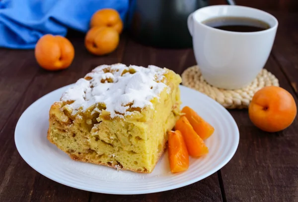 Un morceau de gâteau fait maison avec des tranches de pomme et d'abricot, sucre décoratif en poudre — Photo