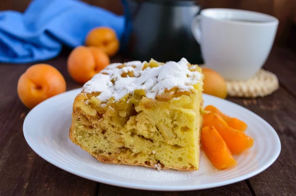 Un morceau de gâteau fait maison avec des tranches de pomme et d'abricot, sucre décoratif en poudre — Photo