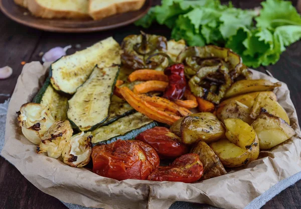 Muchas verduras a la parrilla en un plato (patatas, tomates, zanahorias, cebollas, calabacín ). — Foto de Stock