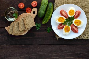 Haşlanmış yumurta ve taze domates, siyah ekmek - hafif diyet kahvaltı. Üst görünüm