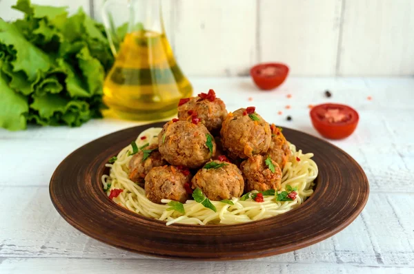 Makaron (spaghetti) z piłkami mięsnymi w glinianych miskach na ciemnym tle. — Zdjęcie stockowe