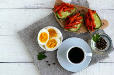 Bir fincan güçlü kahve (espresso), yakın çekim ve kolay diyet kahvaltı - haşlanmış yumurta ve taze sebze (salatalık, kırmızı biber ile kahverengi ekmek). 