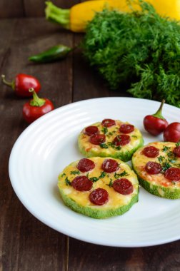 Küçük kabak pizza biberli ve mozzarellalı daire üzerinde. Koyu ahşap arka plan üzerinde.