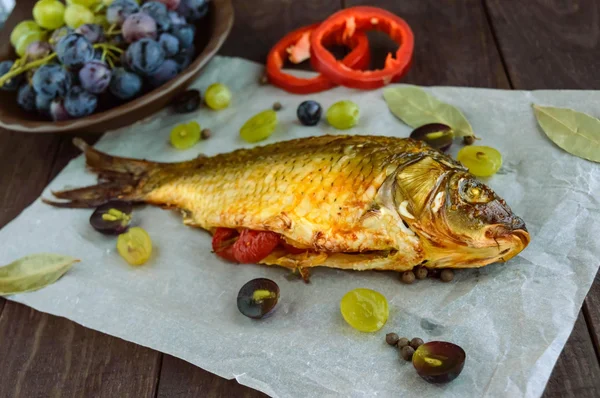 Carpa di pesce al forno, peperoni ripieni e uva . — Foto Stock