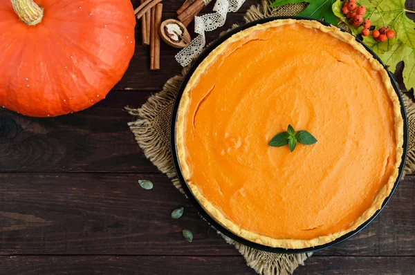 Sweet pumpkin pie on a dark wooden background. The top view. Dietary vegan dish. Traditional baked for Thanksgiving. — Stock Photo, Image