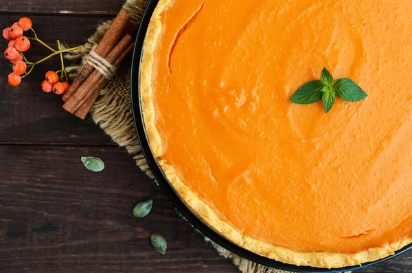 Sweet pumpkin pie on a dark wooden background. The top view. Dietary vegan dish. Traditional baked for Thanksgiving. — Stock Photo, Image
