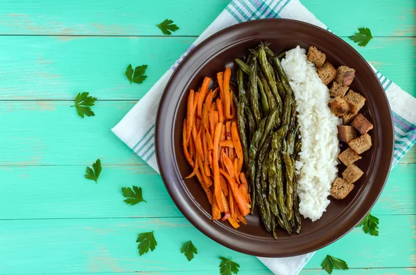 Légumes cuits au four (haricots asperges et carottes), riz bouilli et croûtons de seigle. Cuisine végétarienne. La vue du dessus — Photo