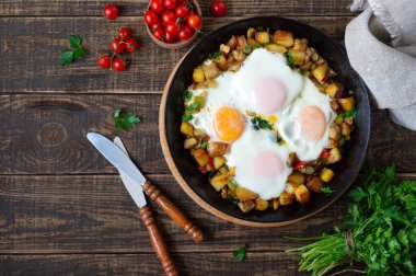 Sebzeli sahanda yumurta kızartma tavasında shakshuka ve eski ahşap arka planda çavdar ekmeği. Geç kahvaltı. Kırsal tarzda. Geleneksel Orta Doğu yemeği. Düz yatıyordu. Üst görünüm