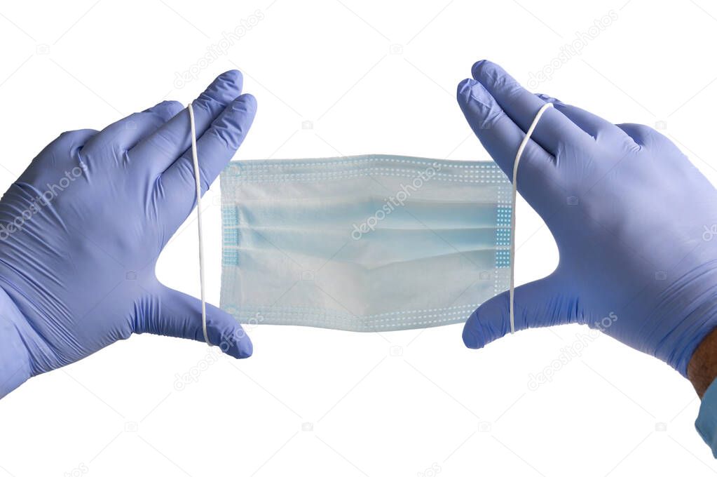 Doctor holds antivirus face mask in hands in blue medical gloves on white background. Countering the virus. Medical masks cover nose and mouth.