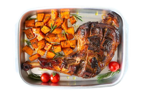 Baked turkey leg, pumpkin slices with spices in a container isolated on a white background. Thanksgiving Day. Meat dish. Top view.