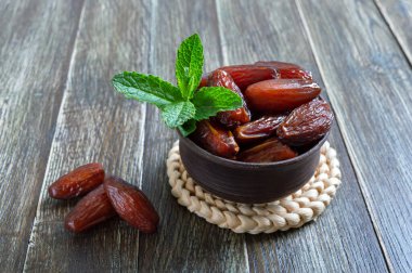 Kurutulmuş meyveler ve taze nane yaprakları ahşap bir masada seramik bir kasede. Organik kurutulmuş meyve.. 