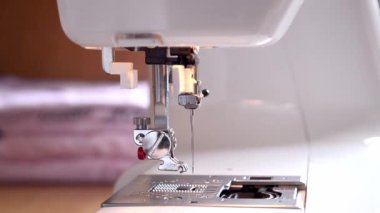 Dikiş makinesini temizliyorum. Ayağını kaldır ve bir fırçayla toz ve enkazı temizle. Yakın plan.