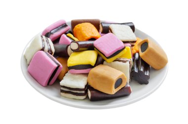 Beyaz arka planda izole edilmiş bir tabakta tatlı meyan kökü şekeri. Geleneksel Fin tatlıları.