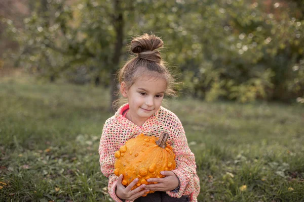 Çocuk ellerinde deforme olmuş çirkin turuncu balkabağı. — Stok fotoğraf