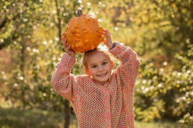 Çocuk ellerinde deforme olmuş çirkin turuncu balkabağı.