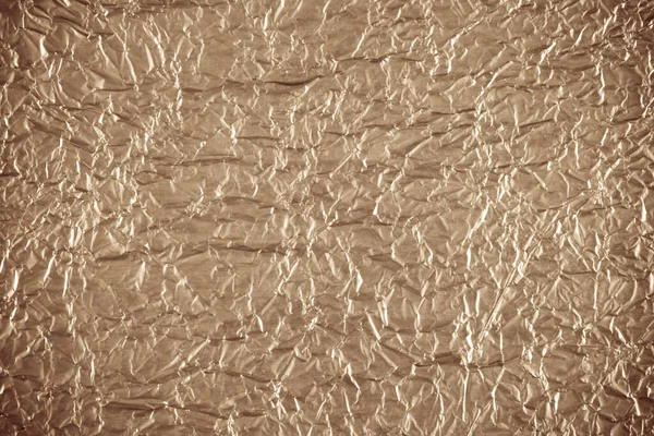 Aluminum crumpled paper. Golden texture abstract background