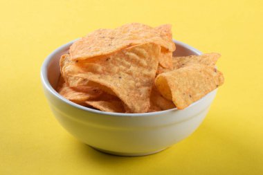 Beyaz kasede sarı arka planda cips.
