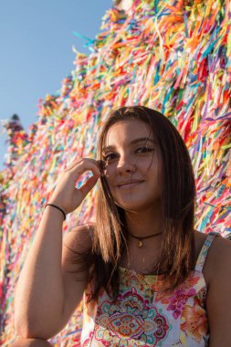 Salvador Bahia Brezilya 'daki Bonfim kilisesinin renkli kurdeleleriyle ızgaranın önündeki kız..