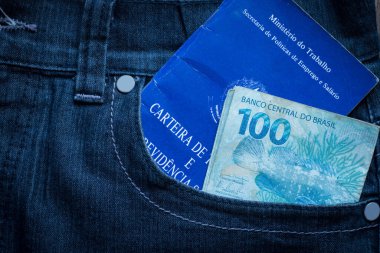 Brezilya iş portföyü ve kot pantolon cebinde yüz gerçek banknot.