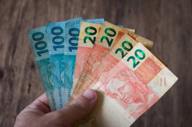 Brezilya 'nın para banknotlarıyla el ele tutuşmak. Finans kavramı