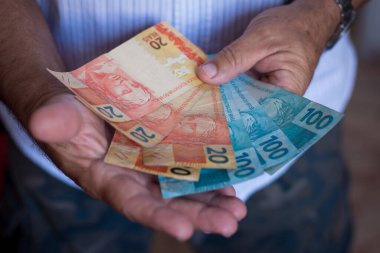 Brezilya 'nın para banknotlarıyla el ele tutuşmak. Finans kavramı