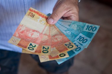 Brezilya 'nın para banknotlarıyla el ele tutuşmak. Finans kavramı