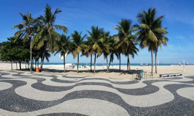 Copacabana Plajı Rio de Janeiro kaldırımı Palmiye ağaçları ve mavi gökyüzü.