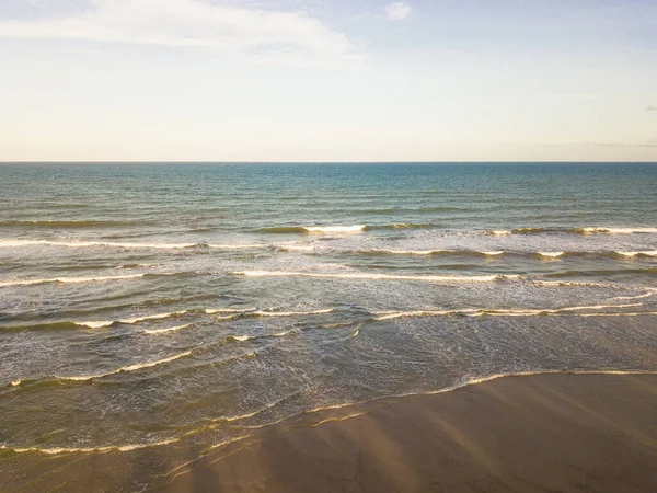 Gün batımında sahildeki okyanus dalgalarının insansız hava görüntüsü..