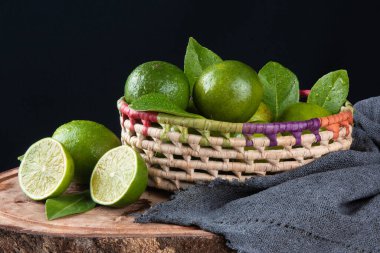 Siyah arka planda yeşil limon meyvesi.