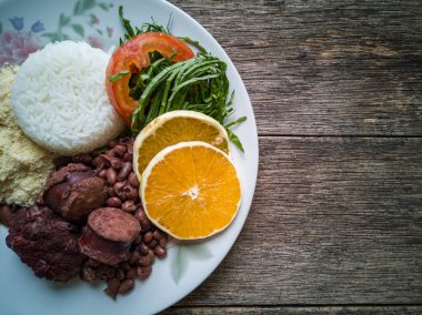 Geleneksel Brezilya feijoadası ve ahşap arka planlı yemek tabağı..
