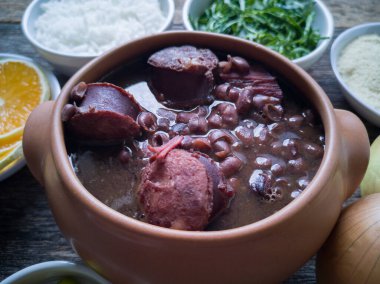 Seramik kasede Feijoada, ahşap arka planda geleneksel Brezilya yemeği..