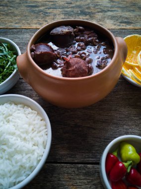 Seramik kasede Feijoada, ahşap arka planda geleneksel Brezilya yemeği..