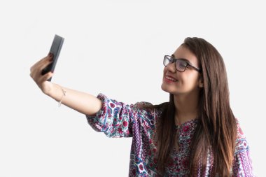 Kız beyaz arkaplan ile selfie çekiyor..